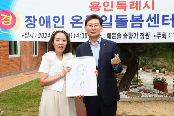 이상일 용인특례시장(오른쪽)에게 직접 그린 캐리커쳐를 선물한 발달장애인 화가 이미경 작가(왼쪽) /사진=용인시