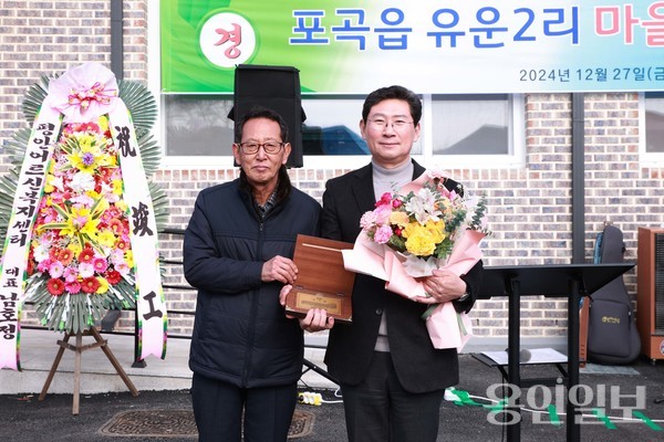 이상일 용인특례시장이 27일 포곡읍 유운2리 마을회관 준공식에서 팔당 상수원 상류지역으로 규제를 받아온 포곡읍 유운2리 주민들로부터 수변구역 해제를 위한 공로에 대한 감사한 마음을 담은 감사패를 받았다.  /사진=용인시