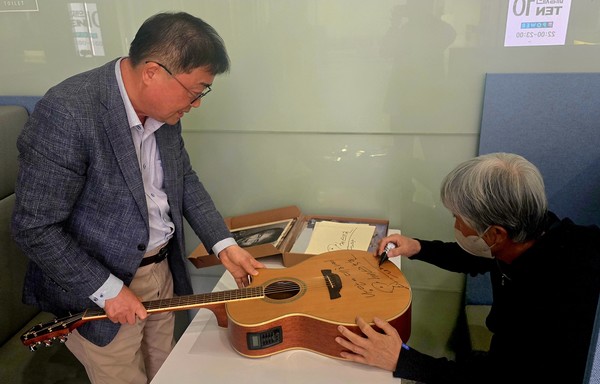 기타에 사인하고 있는 가수 최백호와 필자 ⓒ조대안 